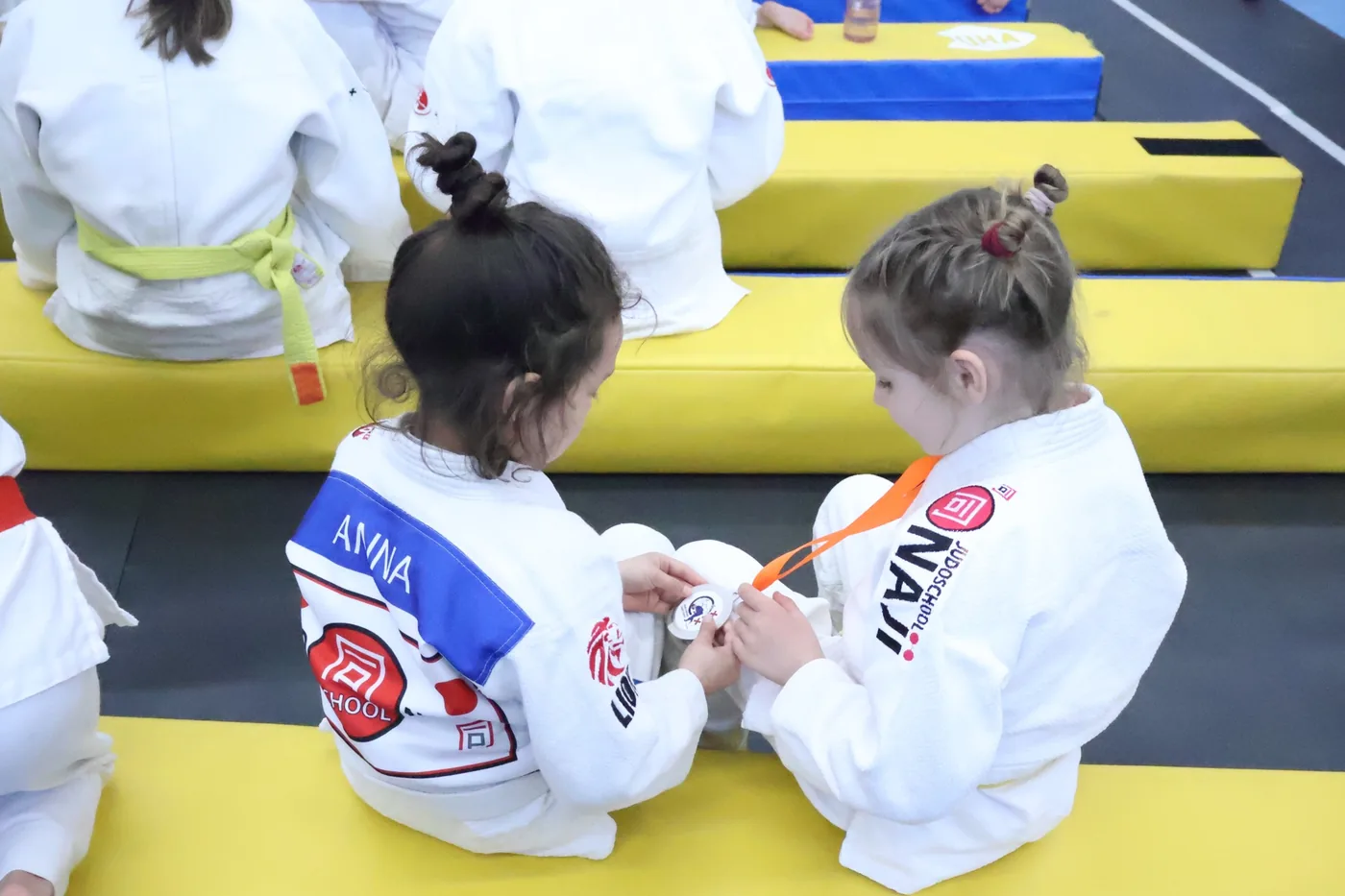 Jonge judoka’s bekijken samen hun medailles tijdens het Amsterdam Judo Event